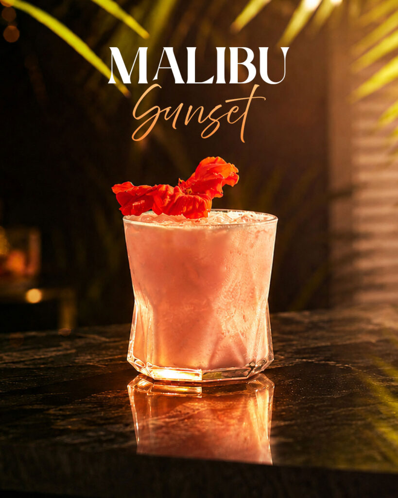 Graphic promoting June Cocktail of The Month, Malibu Sunset, Bursting with tropical flavours and inspired by the beauty of the summer sunsets, it's the perfect seasonal treat. Available now at The Old Quarter, Limerick.